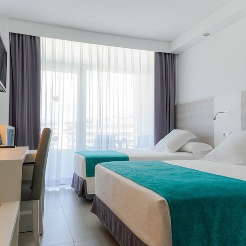 una habitación de hotel con dos camas y una televisión