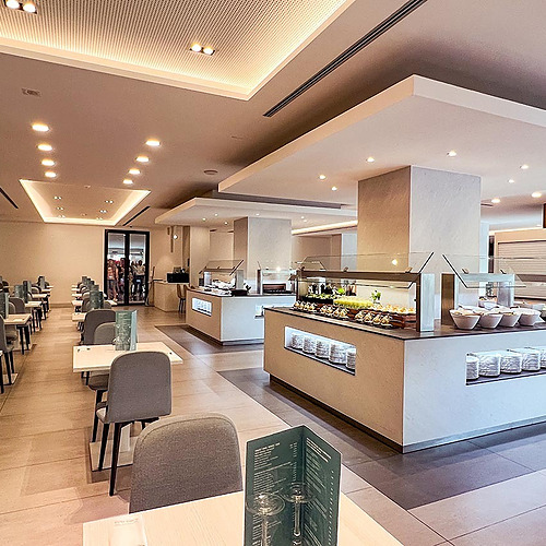 Buffetbereich im Olympus Palace Hotel: moderne Tische, Stühle, LED-Beleuchtung.