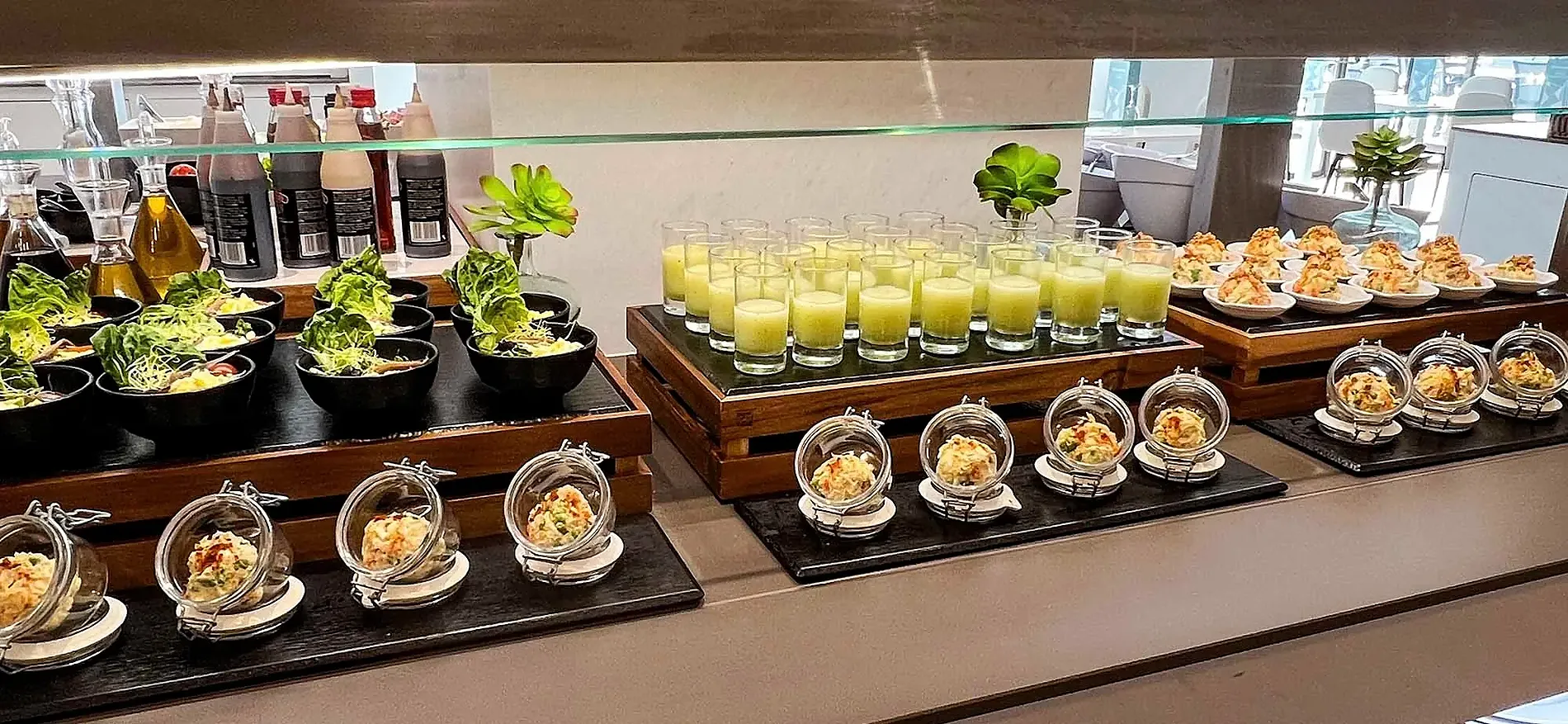 Gourmet buffet display with salads, shots, and appetizers. Gastronomy | Olympus Palace Hotel | Official Website