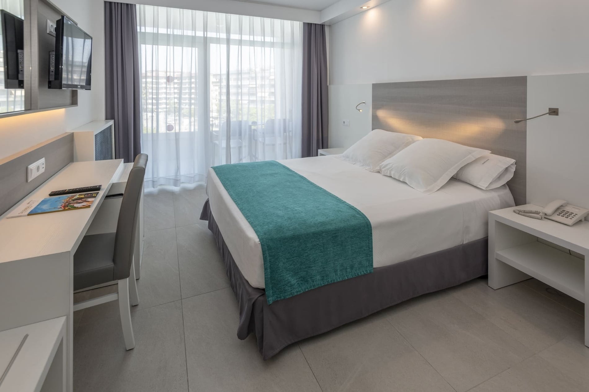 una habitación de hotel con una cama y un escritorio