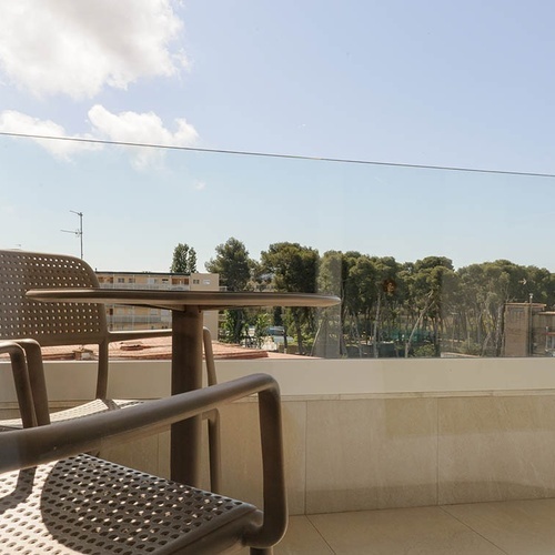 una mesa y una silla en un balcón con vista a la ciudad