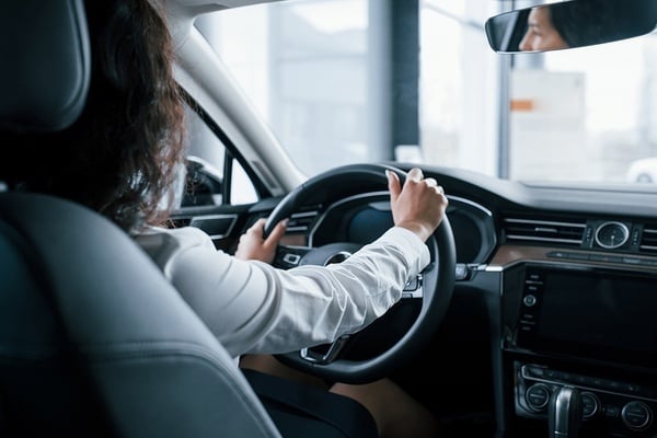 una mujer está sentada en el volante de un coche