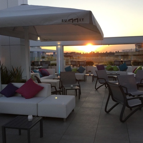 una terraza con muebles y una sombrilla que dice summit