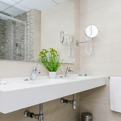 un baño con dos lavabos y un espejo