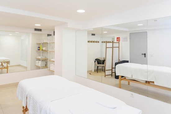 a room with two massage tables and a sign that says ' emergency exit ' on it
