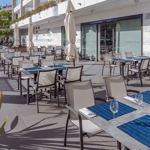 un restaurante al aire libre con mesas y sillas y copas de vino