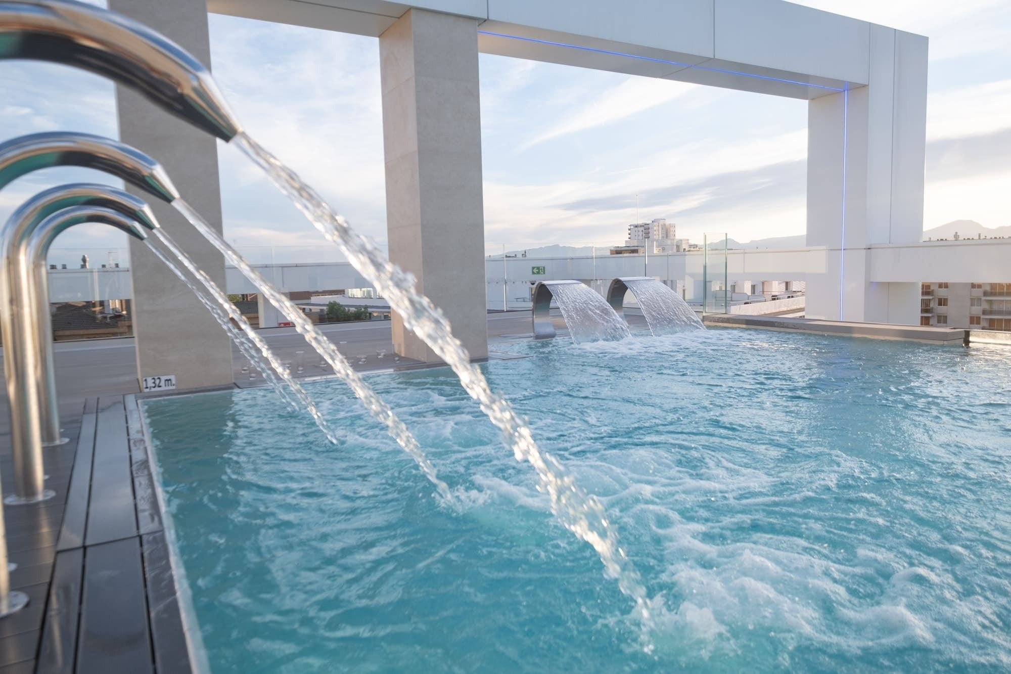 Modern rooftop pool at Olympus Palace with waterfalls