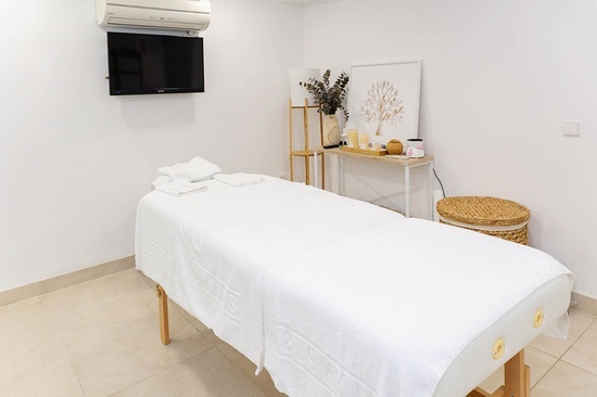 a massage table in a room with a tv above it