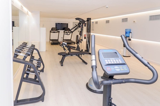 a gym with treadmills dumbbells and an exercise bike
