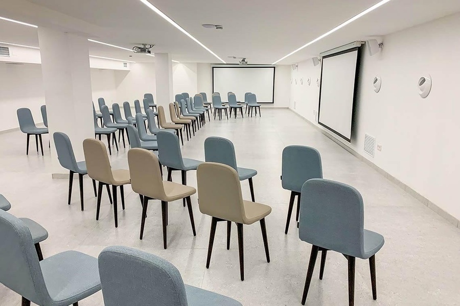 rows of chairs are lined up in front of a projector screen