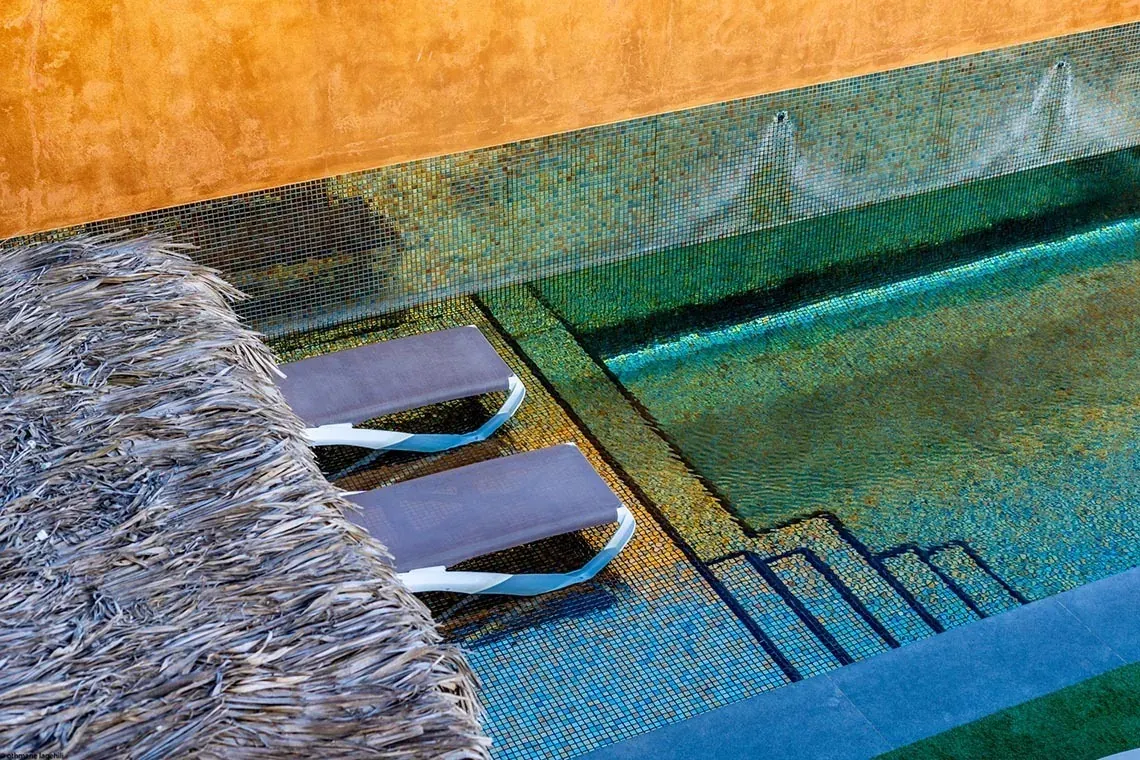 Tumbonas junto a piscina de mosaico en ON Village Matalascañas, tu villa privada en la arena.