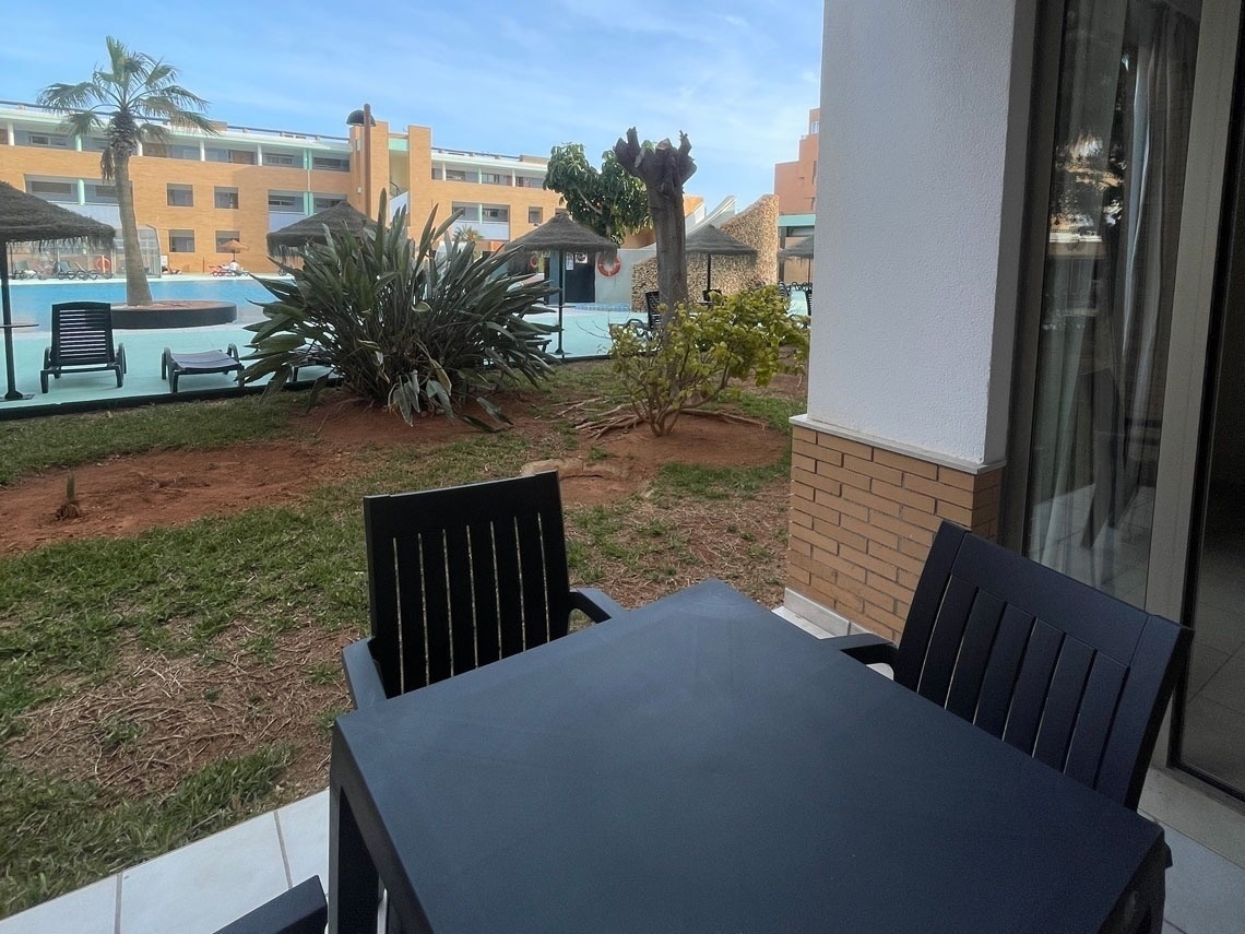 una mesa y sillas en una terraza con vistas a una piscina