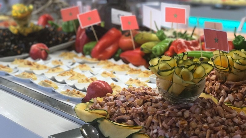 un buffet rempli de fruits et légumes avec des drapeaux dessus