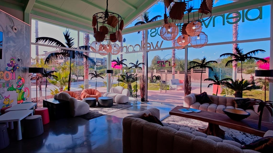 a living room with palm trees and a sign that says welcome