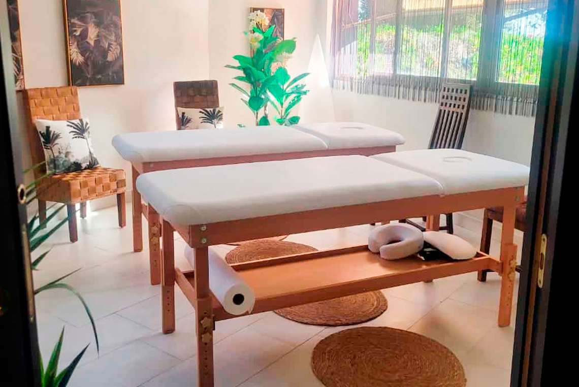 uma sala com duas mesas de massagem e cadeiras