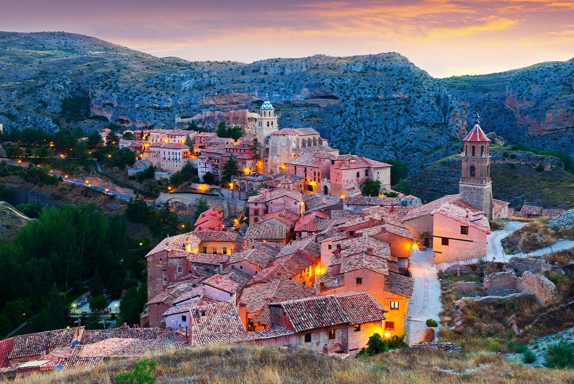 a small town in the middle of a valley with mountains in the background