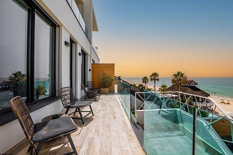 un balcon avec des chaises et une table avec vue sur l' océan