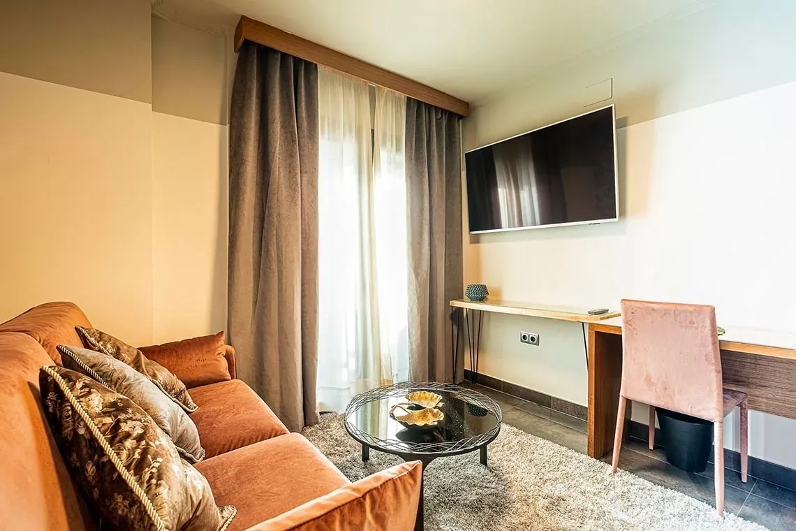 Modern living room in ON Suites Seville, featuring a plush sofa and chic decor.