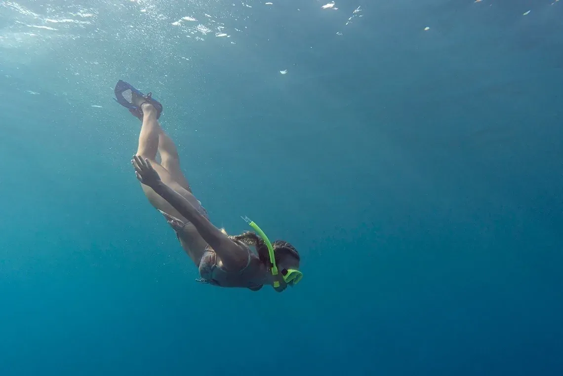 Nadador com snorkel em águas cristalinas, perfeito para estadias nos On Hotels: ON Corporativa.