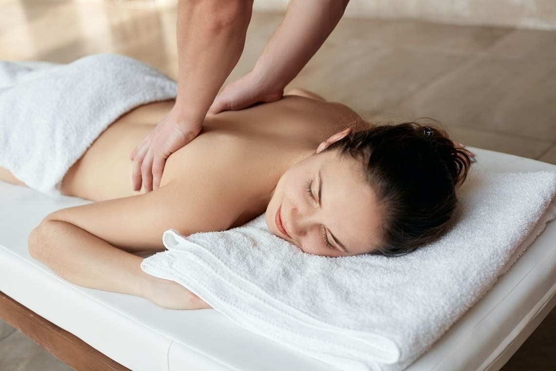una mujer recibe un masaje en la espalda en un spa