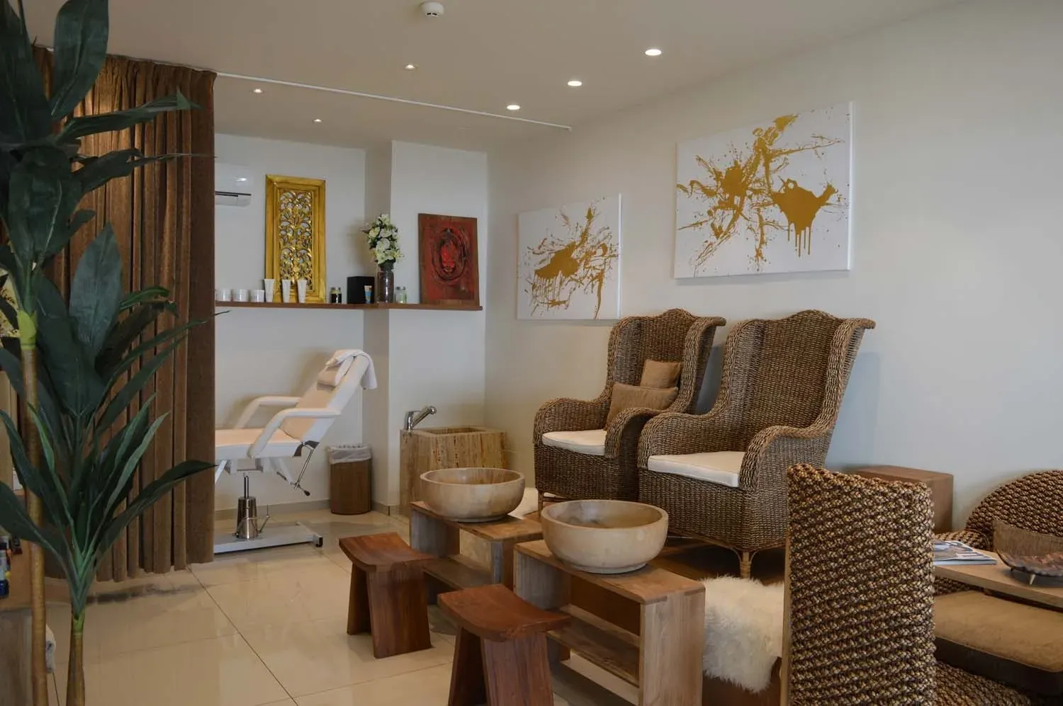 Área de spa ON Hotels: cadeiras de vime, maca e arte abstrata.