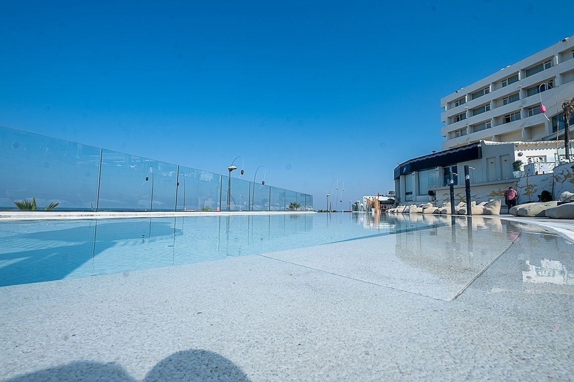 a large swimming pool with a glass fence surrounding it