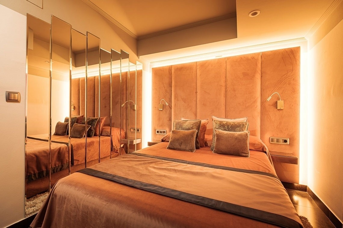 una habitación con una cama y espejos en la pared