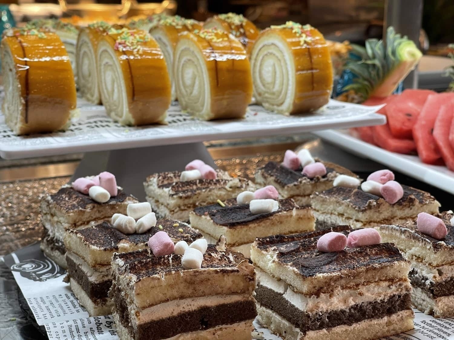 a variety of desserts are displayed on a newspaper covered tray