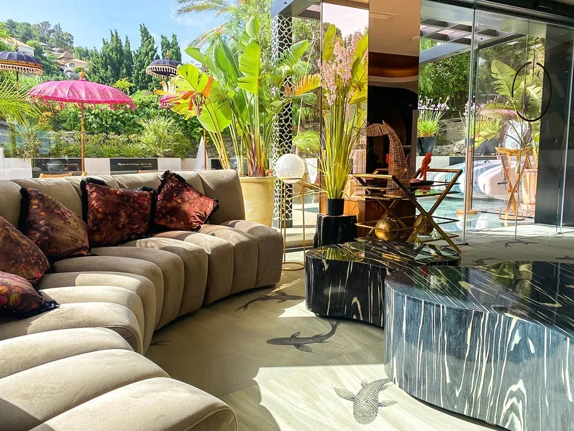 Elegante sala de estar con sofá curvo y mesas de centro en On Aleta Room Almuñecar | On Hotels Group.