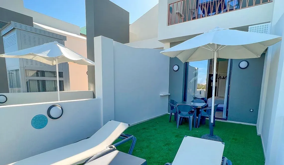 Terrasse ensoleillée avec parasol et salon, sur la Residence Matalascañas | Groupe Hôtels ON | Site officiel