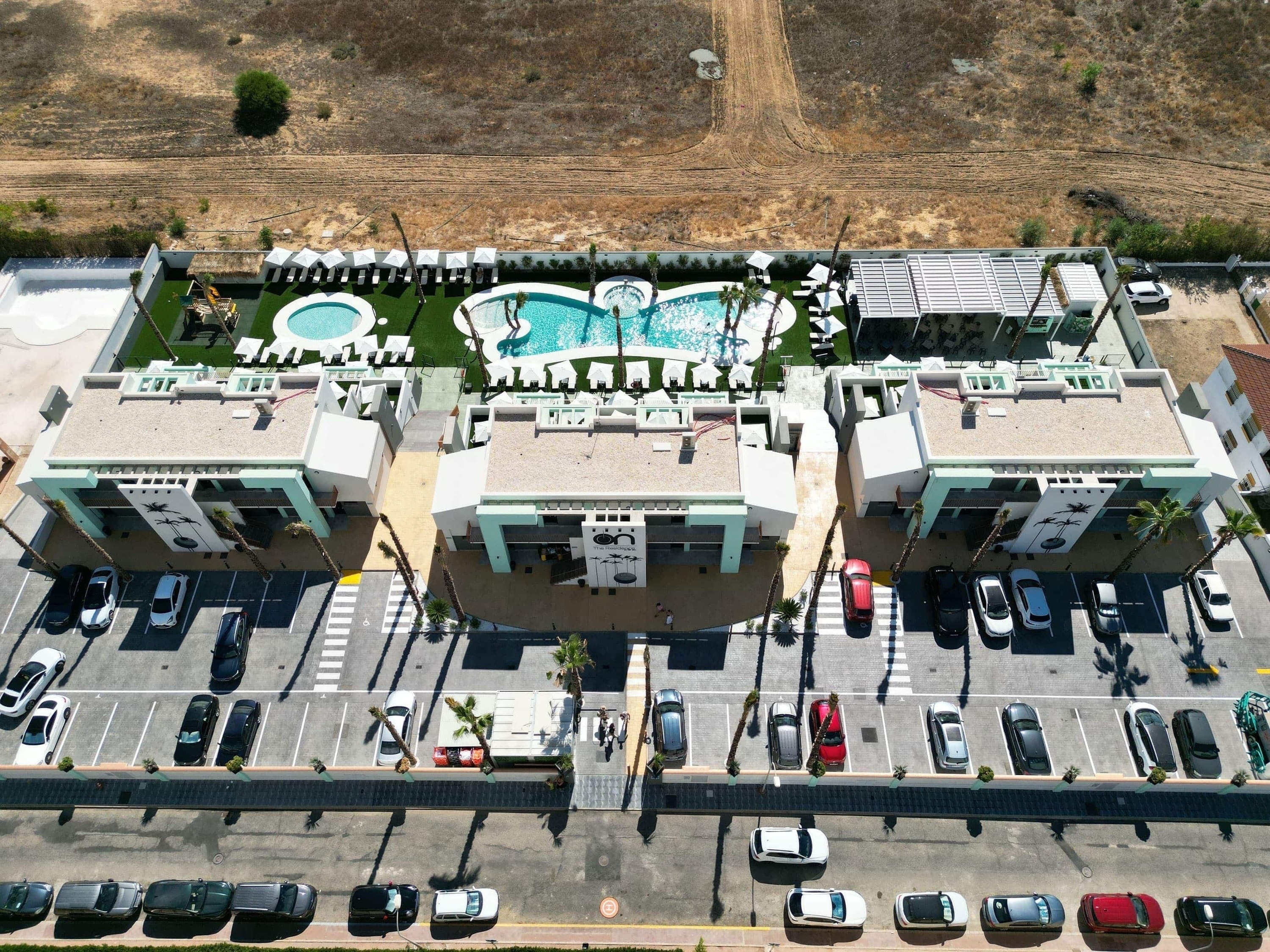 an aerial view of a building with a pool in the background