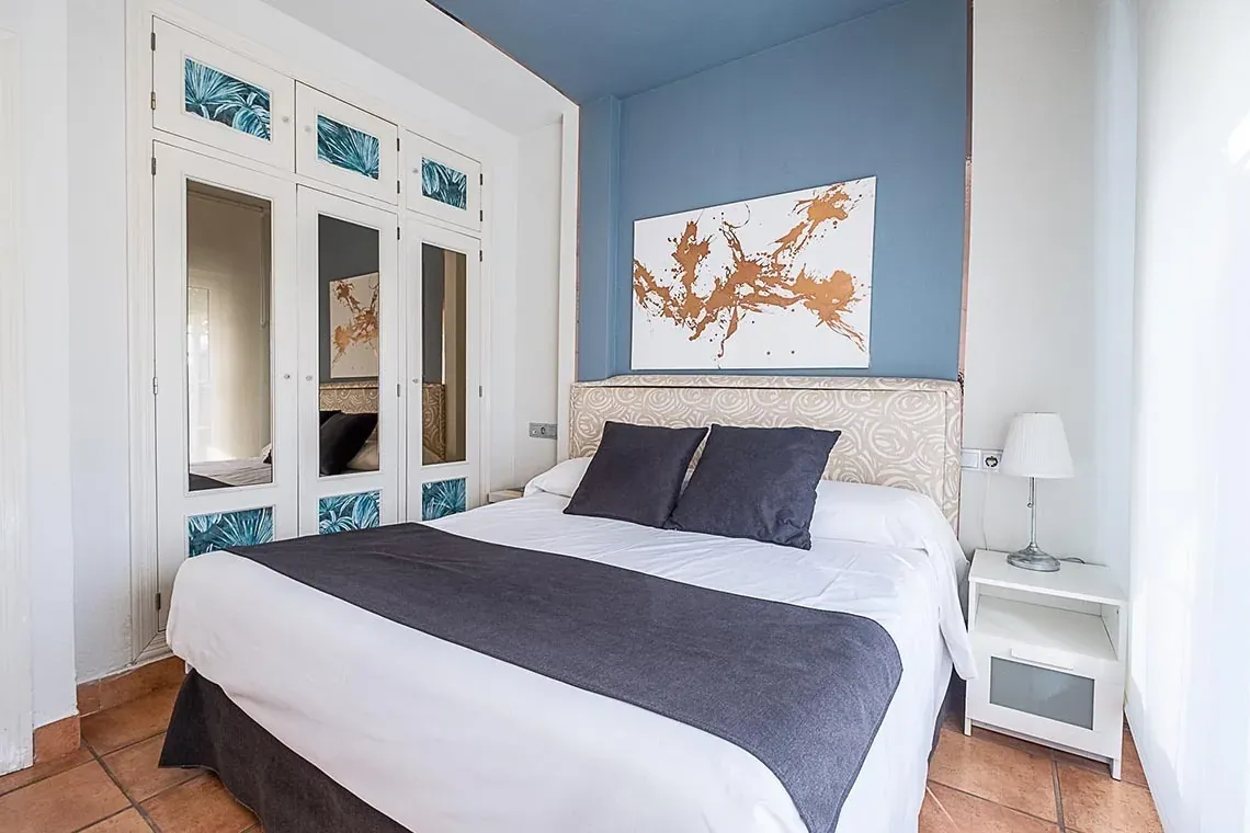 Habitación doble con armario de espejos y arte moderno en ON Family Playa Doñana.