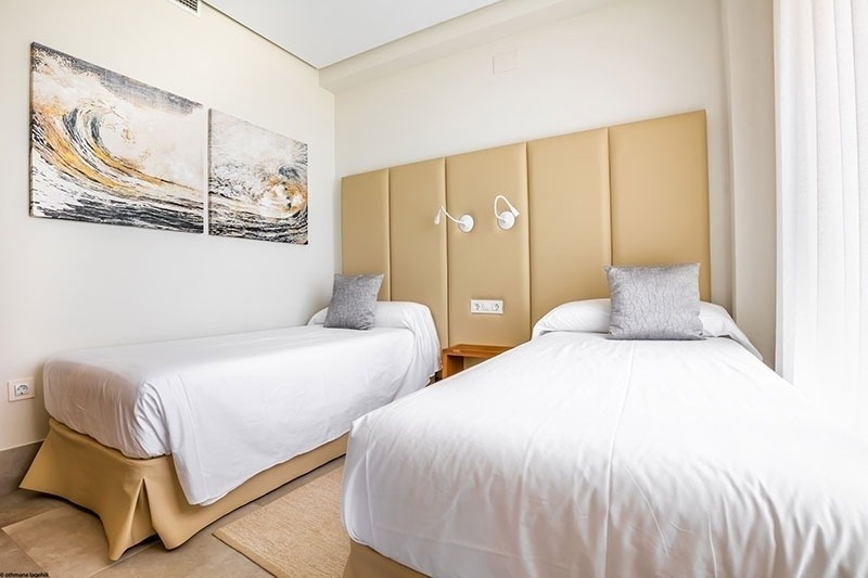 un dormitorio con dos camas y dos cuadros en la pared