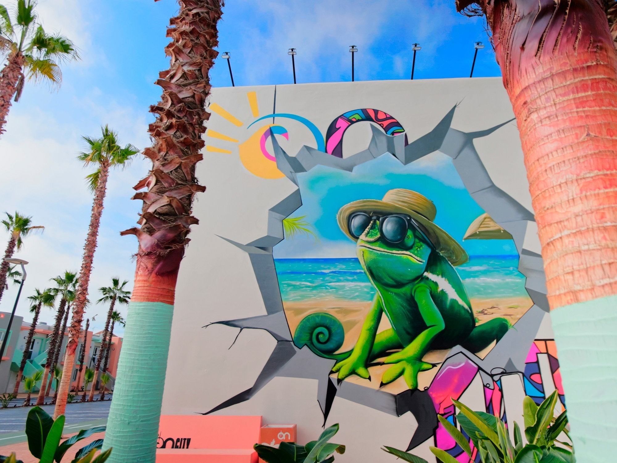 una pintura de un camaleón con un sombrero y gafas de sol