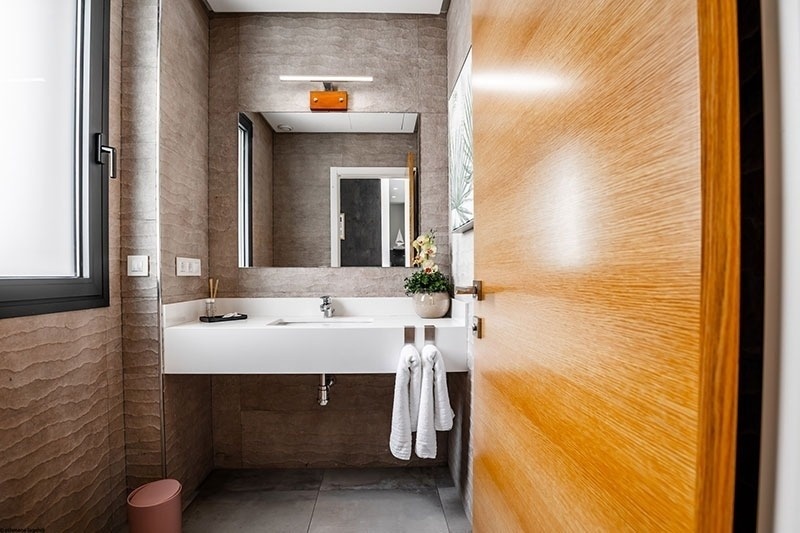 un baño con lavabo y espejo y una puerta de madera