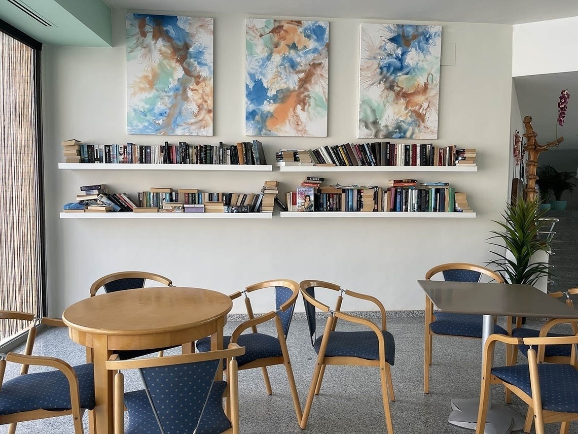 a room with tables and chairs and books on shelves