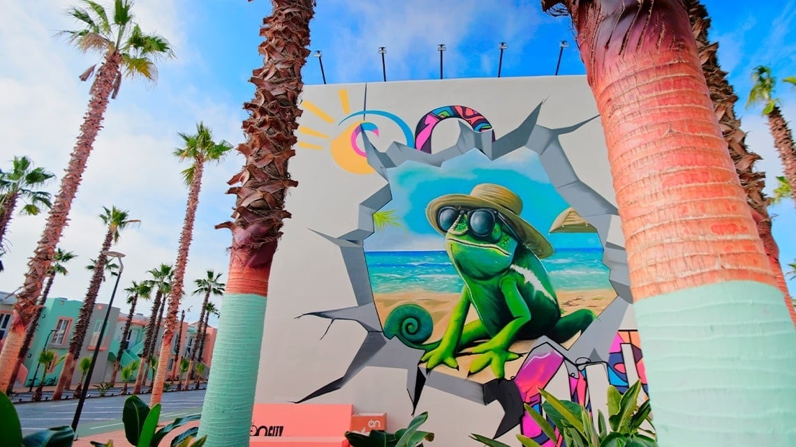 a mural of a chameleon wearing sunglasses and a hat