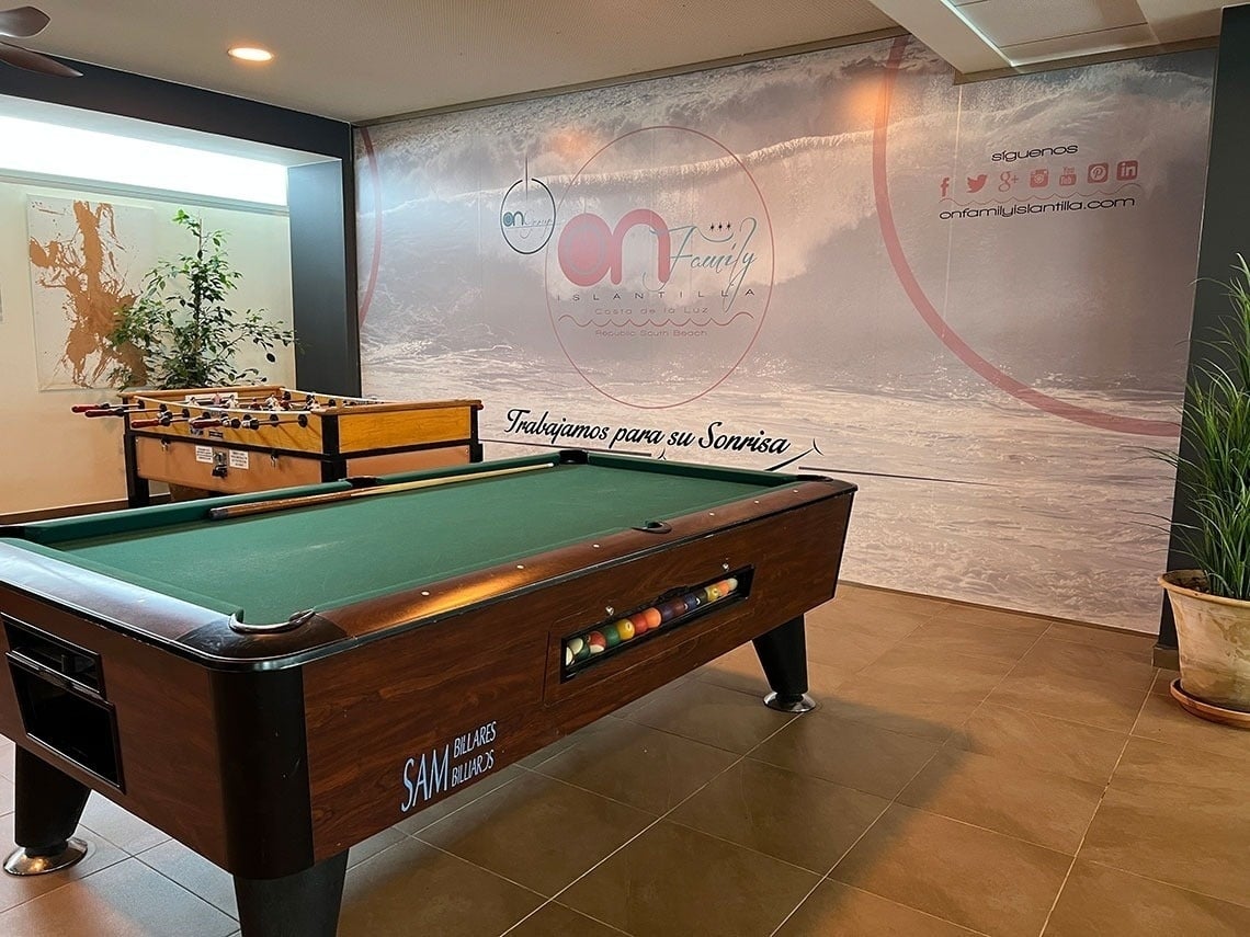 a pool table in front of a wall that says on family