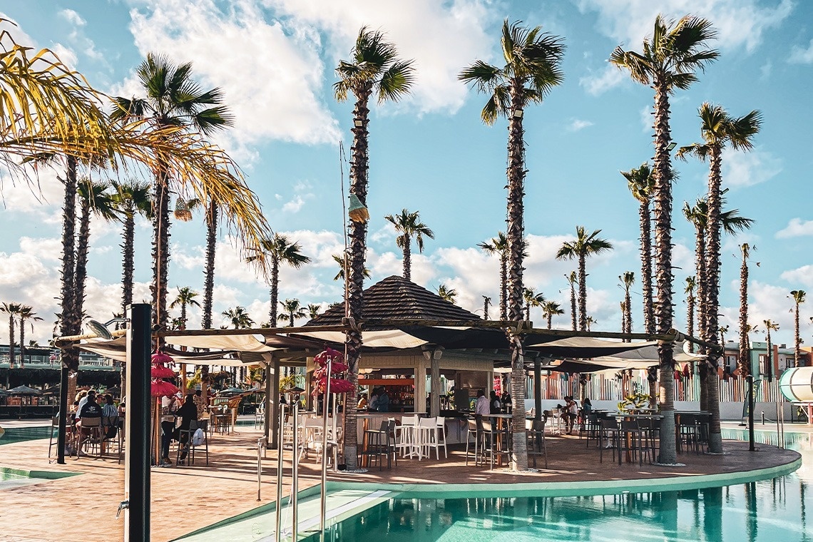 dos copas de champán con bebidas y sombrillas en la piscina