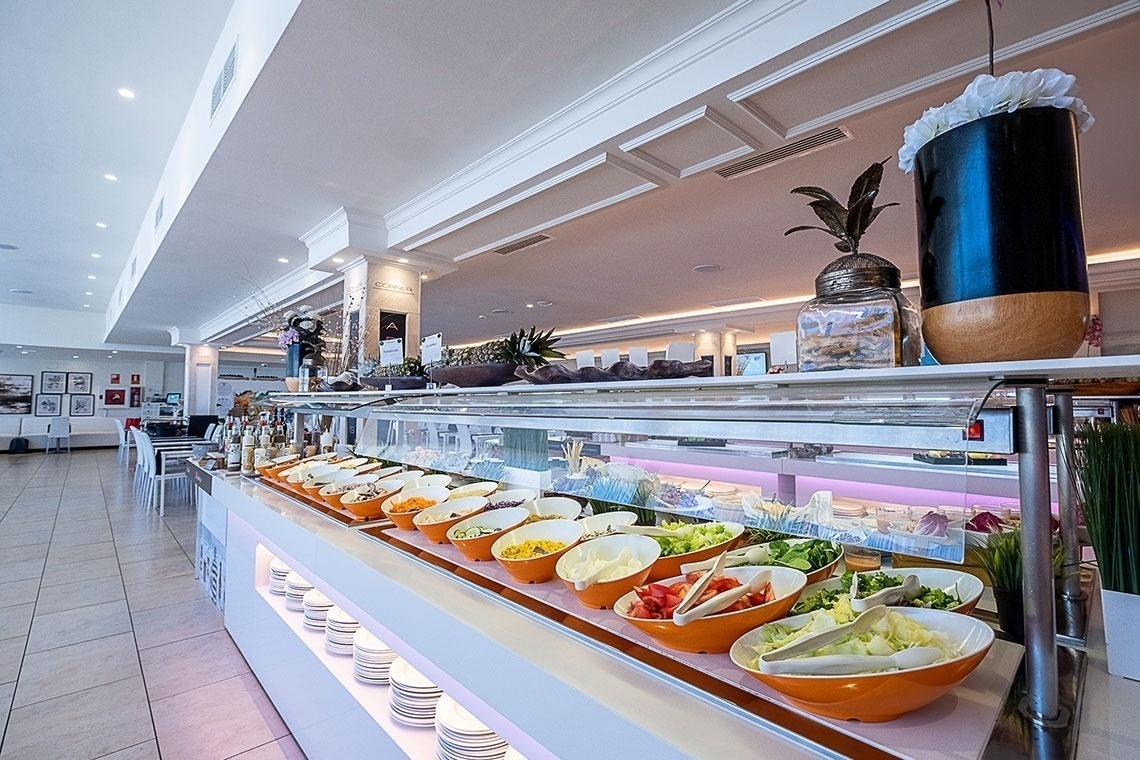 un mostrador de ensaladas en un restaurante con platos y cubiertos