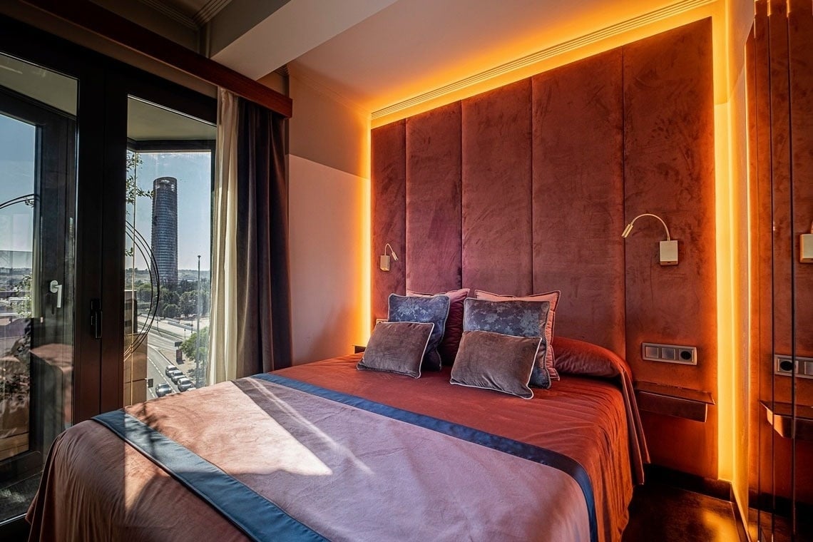 a bed in a hotel room with a view of a city