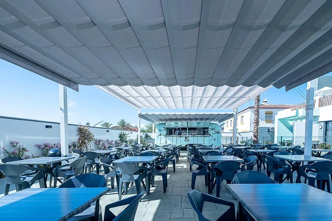 Terrasse de restaurant extérieure avec tables, chaises et food truck. On the Residence Matalascañas | Groupe Hôtels ON | Site officiel.