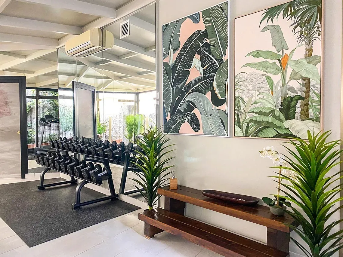 Gimnasio moderno con pesas y arte tropical en On Aleta Room Almuñecar.