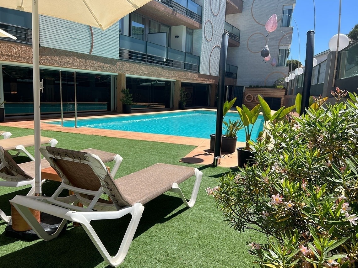 a swimming pool is surrounded by lawn chairs and umbrellas