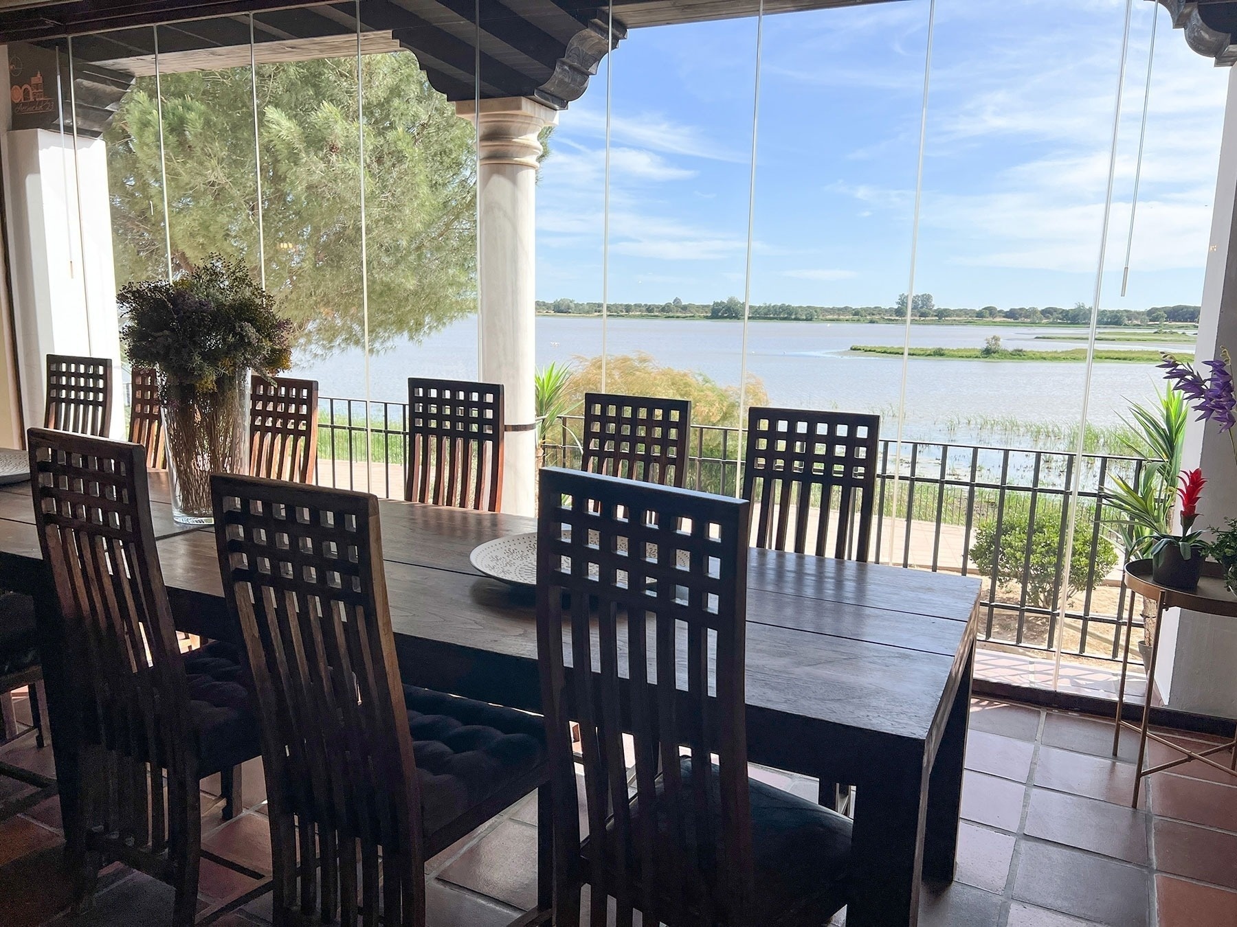 a dining room table and chairs with a view of a lake