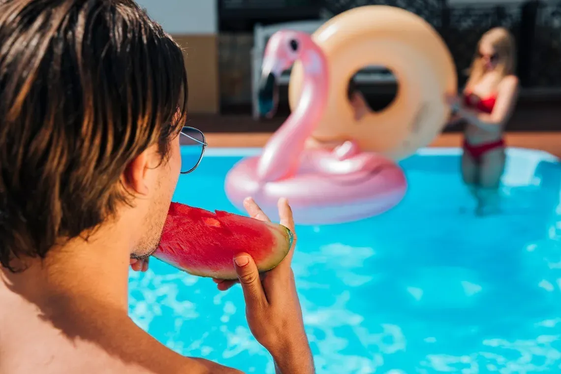 Homem comendo melancia na piscina. On Hotels: ON Corporativa.