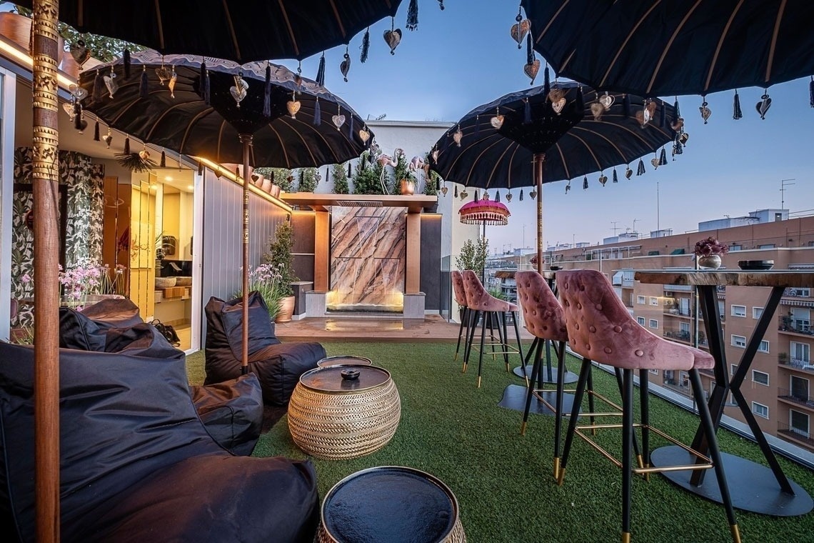 a rooftop patio with umbrellas and chairs