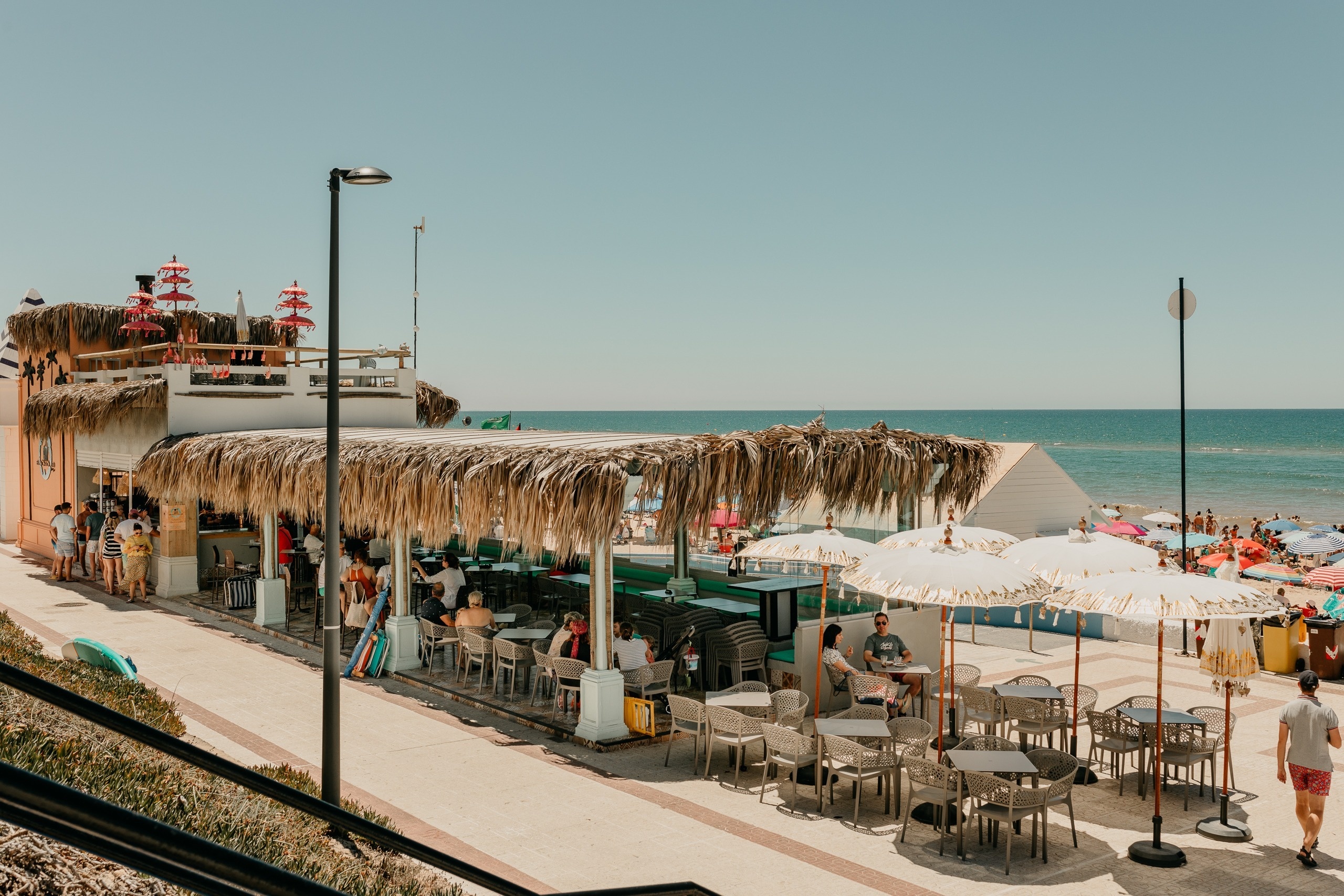 two drinks with umbrellas on top of them are next to a pool