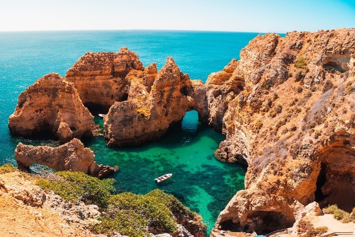 a boat is in the middle of a small body of water surrounded by rocks