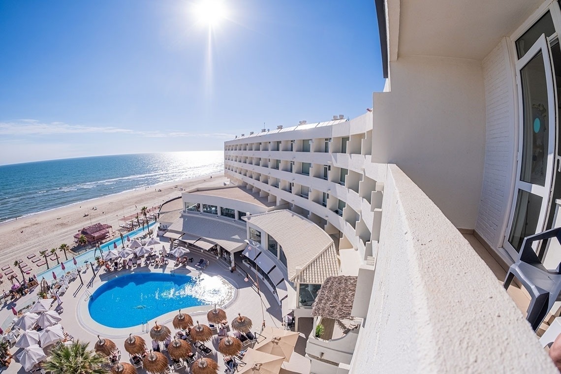 una vista aérea de un hotel con piscina y playa